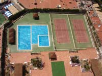 View of pool and tennis court area of Gemelos 2 Apartments